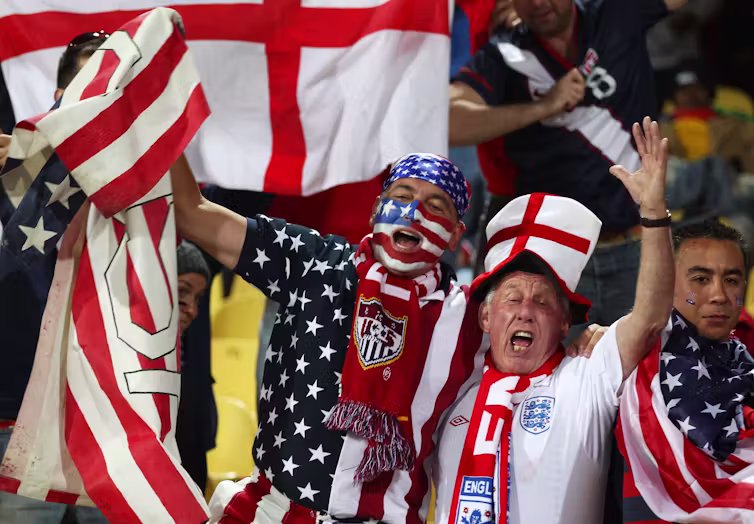 Soccer fans in English and USA garb celebrate together.