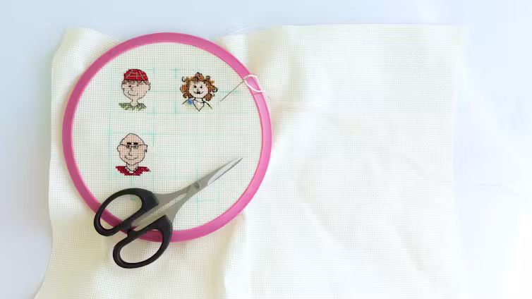 A cross-stitch featuring mini portraits of three adults.
